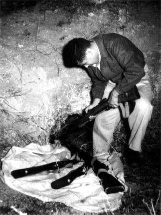 Un miembro de una organización clandestina de defensa escondiendo rifles, 1947