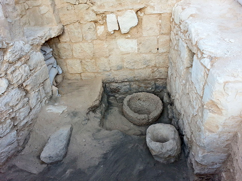 The stable’s interior. The round stone basins were apparently used for storing food and water for the animals.