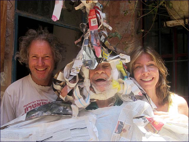 Adam Yakin, his father Abraham Yakin (adorned with newspapers) and his partner Sarah Brown get ready for The Citadel of Golems