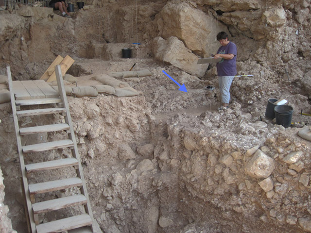 Qesem Cave during excavation, with arrow pointing to the hearth