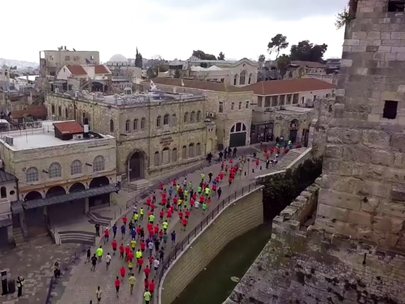 Runners entering the Old City from the Jaffa Gate and passing David's Citadel