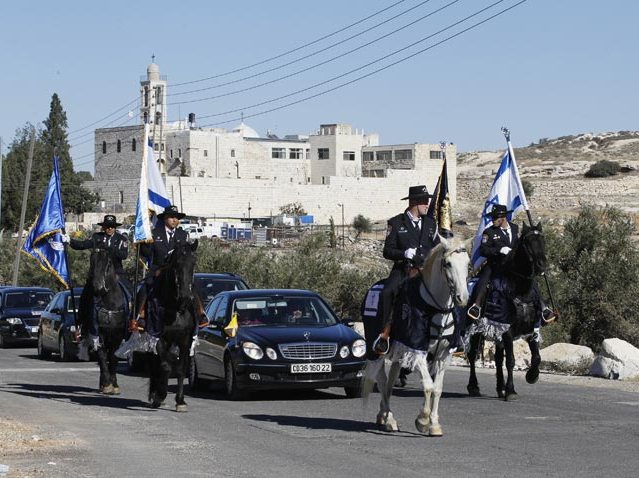 Horse-mounted Israeli police officers escort Latin Patriarch of Jerusalem Fouad Twal from Jerusalem to attend Christmas celebrations in Bethlehem