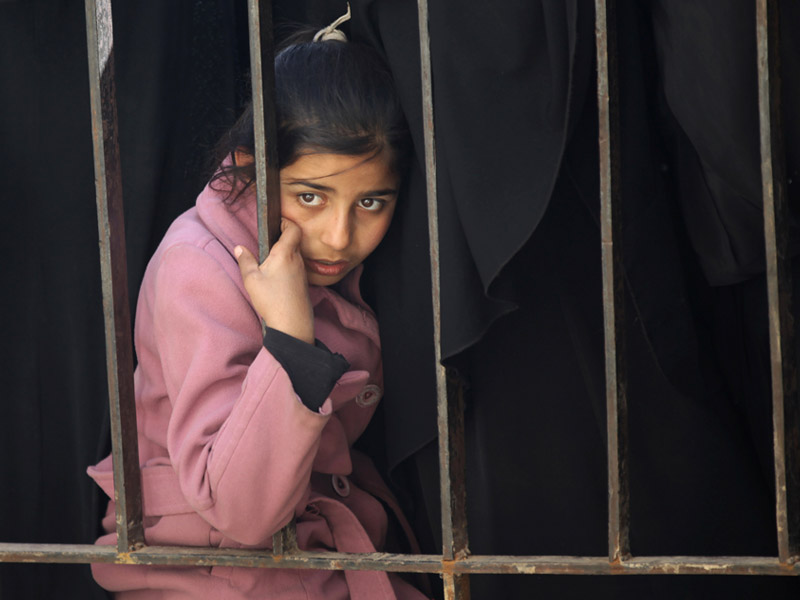 A displaced Syrian refugee waits to receive food in northern Aleppo countryside.