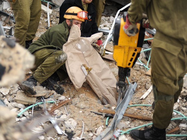 IDF Home Front Command search and rescue soldier pulls a dummy out of the rubble in an exercise