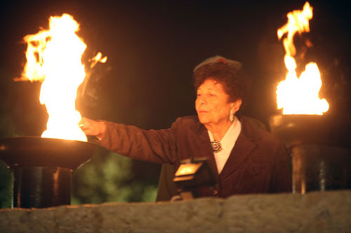 Holocaust survivor Artemis Miron lights one of the six torches at the ceremony