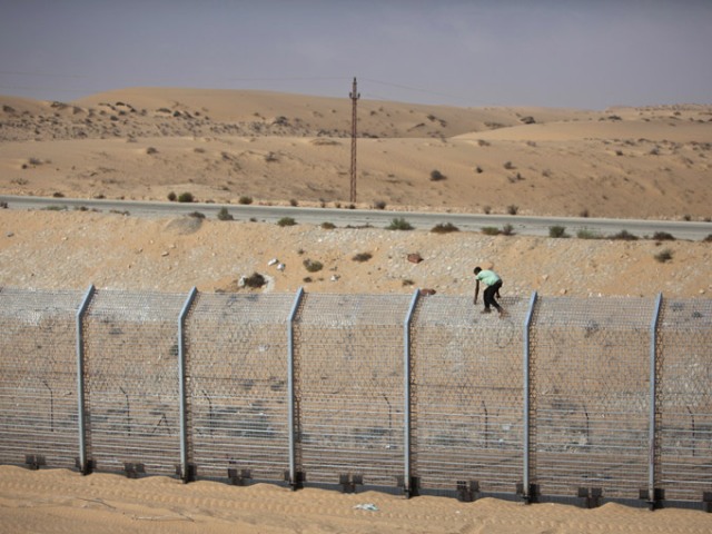 A laborer works on the border fence between Israel and Egypt