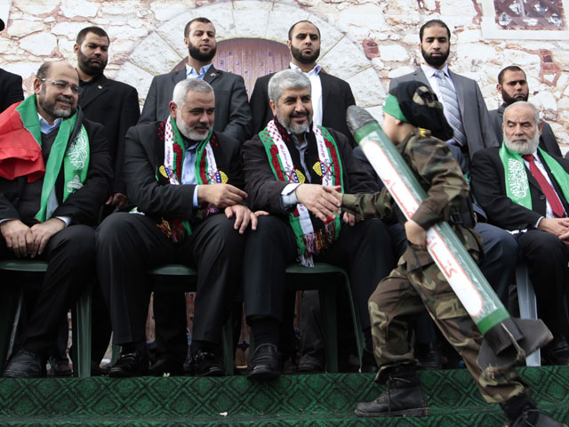 Palestinian boy carrying a model of a rocket shakes hands with Hamas chief Mashaal in Gaza, 8 Dec 2012