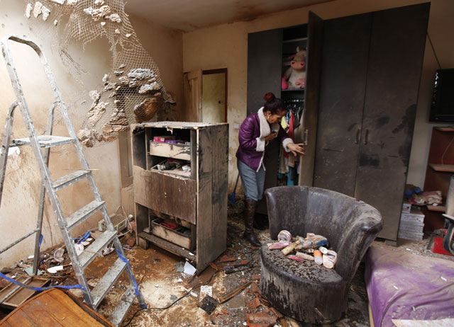 Tami Shadadi surveys damage to her house in Sderot after it was hit by a rocket fired from Gaza