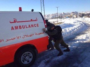 IDF soldiers help Palestinian ambulance stuck in the snow carrying a very sick woman