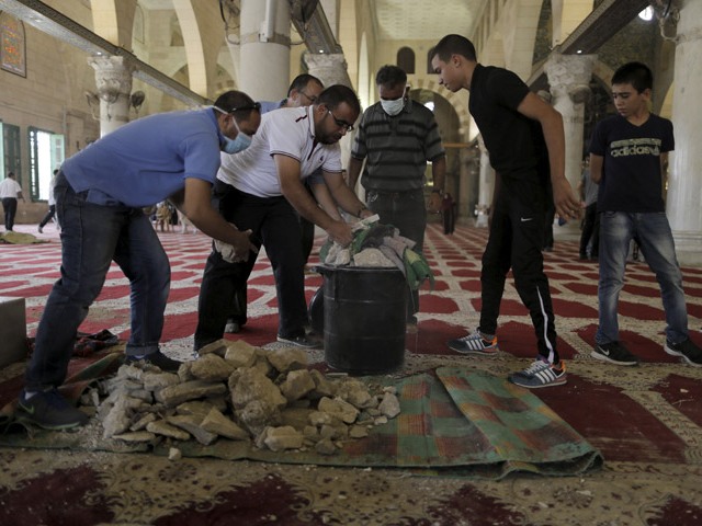 Palestinians gather stones that were stored in the al-Aqsa mosque beforehand