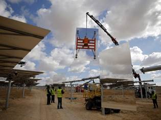 Crane lifts huge mirrors during construction of solar-power tower in the Negev