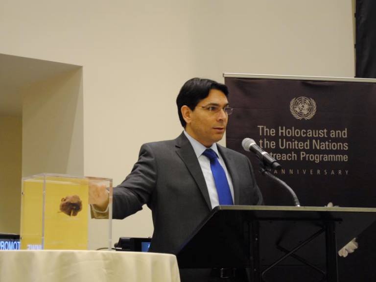 Ambassador Danon presents a burnt stone salvaged from the Great Synagogue in Mannheim